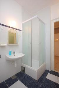 科米扎Apartments by the sea Komiza, Vis - 8533的白色的浴室设有水槽和淋浴。