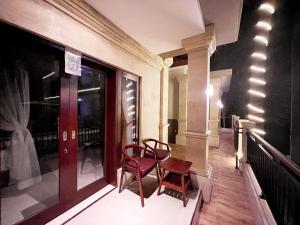 八丹拜Bali 85 Beach Inn的阳台配有两把椅子和窗户。