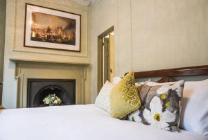诺里奇38圣吉尔斯旅馆的一间卧室配有一张带枕头的床和壁炉