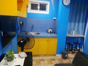 马尼拉bluenest apartment的蓝色和黄色的厨房,配有水槽和风扇
