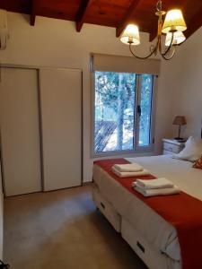 马德拉潘帕斯Cabañas Antares的一间卧室设有一张床和一个大窗户