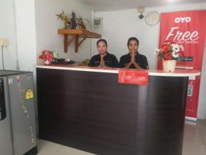 芭堤雅市中心OYO 75414 KJS Pattaya​的两个女人坐在商店的柜台上