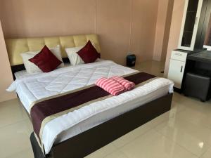 芭堤雅市中心OYO 75414 KJS Pattaya​的一张床上的红色枕头