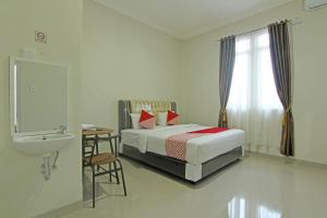 巴东Capital O 91675 Utama Residence的一间卧室配有床、水槽和卫生间