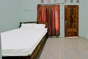 普拉亚SPOT ON 91771 Homestay Bang Haji的一间卧室设有床、窗户和门
