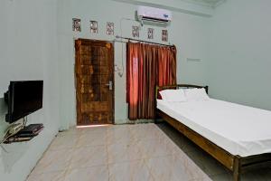 普拉亚SPOT ON 91771 Homestay Bang Haji的卧室配有床、电视和门
