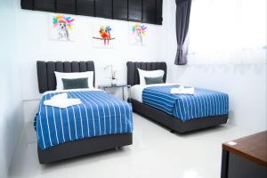 班怀雅Baan Nern Khao Resort Pattaya的一间卧室配有两张蓝色和白色条纹的床
