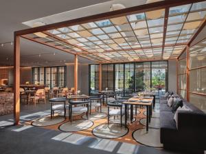 杭州杭州上城英迪格酒店（近西湖，钱塘江畔，设计师酒店，入住尊享首轮minibar欢饮礼遇）的餐厅设有桌椅和窗户。
