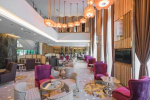 普特拉贾亚Zenith Hotel Putrajaya的餐厅设有紫色桌椅和吊灯