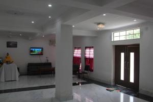 菩提伽耶HOTEL BODHGAYA INN的客厅配有沙发和墙上的电视