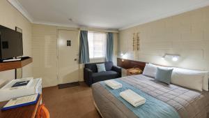 库纳巴拉布兰马修福林达斯汽车旅馆的酒店客房配有一张床、一把椅子和一台电视。