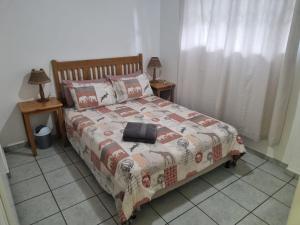 马盖特Margate Beachfront Apt for 6 adults 2 kids的一间卧室配有一张带毯子的床和两张桌子
