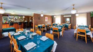 库纳巴拉布兰马修福林达斯汽车旅馆的一间设有蓝色桌椅的餐厅和一间酒吧
