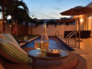 今归仁村Pool Villa Imadomari by Coldio Premium的一瓶葡萄酒和一碗水果放在桌子上