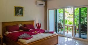圣吉吉Senggigi Homes & Apartments的一间卧室配有红色枕头的床