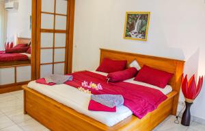 圣吉吉Senggigi Homes & Apartments的一间卧室配有一张带红色枕头的大床