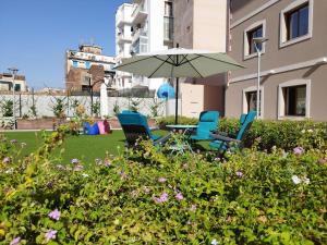 卡塔尼亚ROOMS alCentro的院子里设有两把椅子和一张桌子及一把遮阳伞