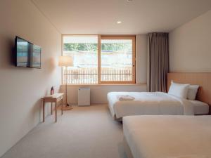 Hatago Vison的酒店客房设有两张床和窗户。