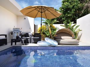 今归仁村Pool Villa Imadomari by Coldio Premium的游泳池旁的游泳池及其遮阳伞