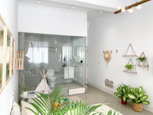 高雄闆娘公寓的白色的浴室设有玻璃淋浴间和植物