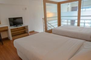 峇六拜The CEO Executive Suites的酒店客房设有两张床和电视。