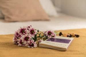 格拉纳达Rooms Vita的坐在桌子上,花朵上,书