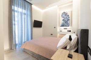 伊西翁BillMar Luxury Apartment in the center of Gythio的一间卧室设有一张床和一个大窗户