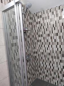 法马古斯塔Secret garden no:01的浴室设有棕色和灰色瓷砖淋浴。