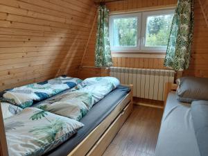 纳梅斯托沃Chata na Orave so saunou a kúpacou kaďou的小木屋内带两张床的房间