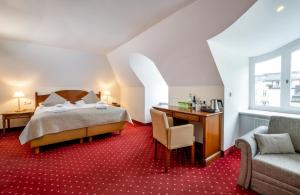 萨尔茨堡米拉贝尔广场奥斯超泰尔酒店的一间卧室配有一张床、一张桌子和一把椅子