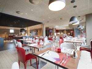 里尔里尔欧洲里尔钟楼酒店的一间设有白色桌子和红色椅子的餐厅