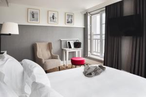 佩罗斯-吉雷克Grand Hôtel Perros-Guirec的配有一张床和一把椅子的酒店客房