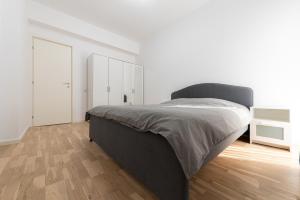 布加勒斯特Ines的一间卧室设有一张大床,铺有木地板