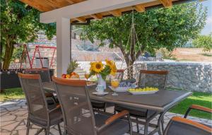 RunovićCozy Home In Runovic With Outdoor Swimming Pool的天井配有餐桌和椅子,设有秋千