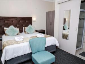 布隆方丹Morning flair Bed and Breakfast的一间卧室配有一张大床和蓝色椅子