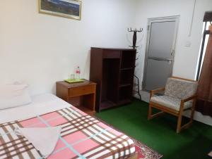 博卡拉Gurkha Lodge的一间卧室配有一张床、一把椅子和一张书桌