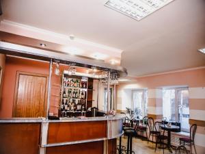 派蒂哥斯卡Yuzhnaya Hotel的一间酒吧,位于一间配备有桌椅的房间内