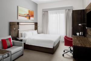 迪拜迪拜互联网城快捷假日酒店的酒店客房,配有白色的床和椅子