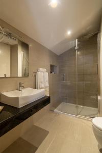明德卢Luna Boutique Hotel的带浴缸、水槽和淋浴的浴室
