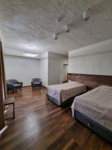 伊杰万Apaga Resort的一间酒店客房,配有两张床和椅子
