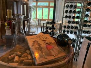 埃沃莱讷Hôtel Restaurant Eden的装在篮子里的一本书,装上一瓶葡萄酒