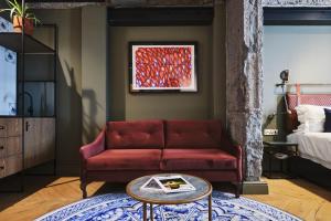 开普敦Gorgeous George by Design Hotels ™的客厅配有红色的沙发和桌子