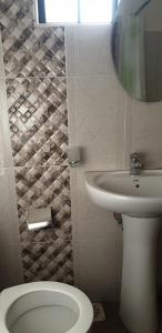 内罗毕Sochati Casa Resort的一间带卫生间、水槽和镜子的浴室
