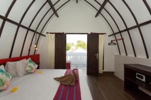 吉利特拉旺安Kidi's Lodge Gilitrawangan的一间带床的卧室,位于带窗户的房间内