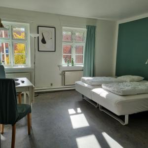 灵斯泰兹Danhostel Ringsted的一间卧室设有两张床、一张桌子和窗户。
