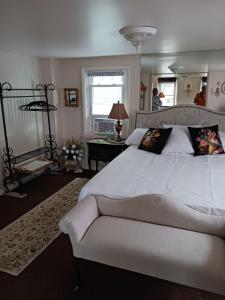 MoosicThe guest house at the regina house tea room的卧室设有一张白色大床和一扇窗户。