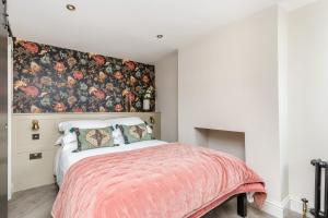 HurstpierpointThe Oak Rooms - Stylish & luxurious stay in Sussex by Huluki Sussex Stays的一间卧室配有一张带花卉图案墙壁的床