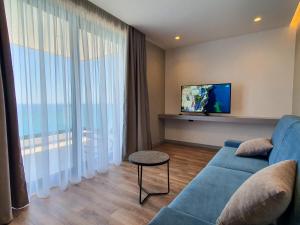 萨兰达LOOKOUT Apartments的客厅配有蓝色的沙发和电视