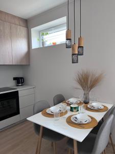 拉克韦雷Kastani Apartments的一间带白色桌椅的厨房和一间用餐室