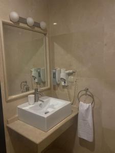 内尔哈三个太阳旅馆的浴室设有白色水槽和镜子
